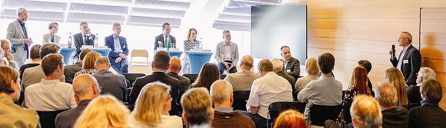 Podiumsdiskussion mit allen Referentinnen und Referenten vor Publikum